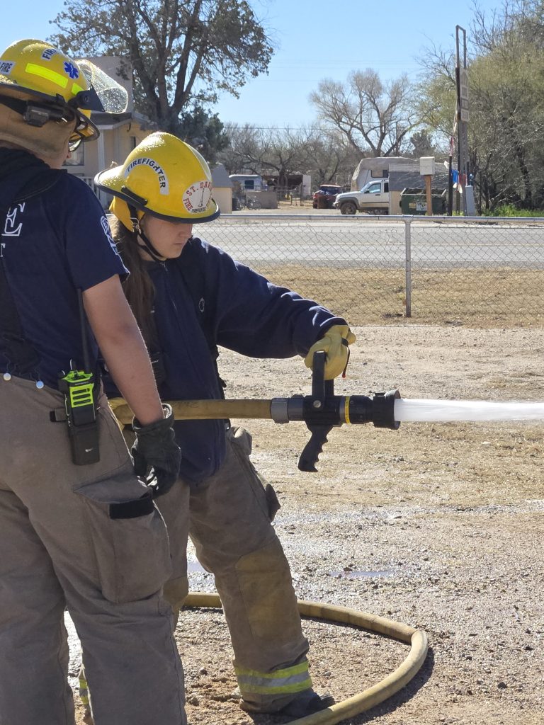 Saint David Fire District members practicing basic fire hose handling during training.