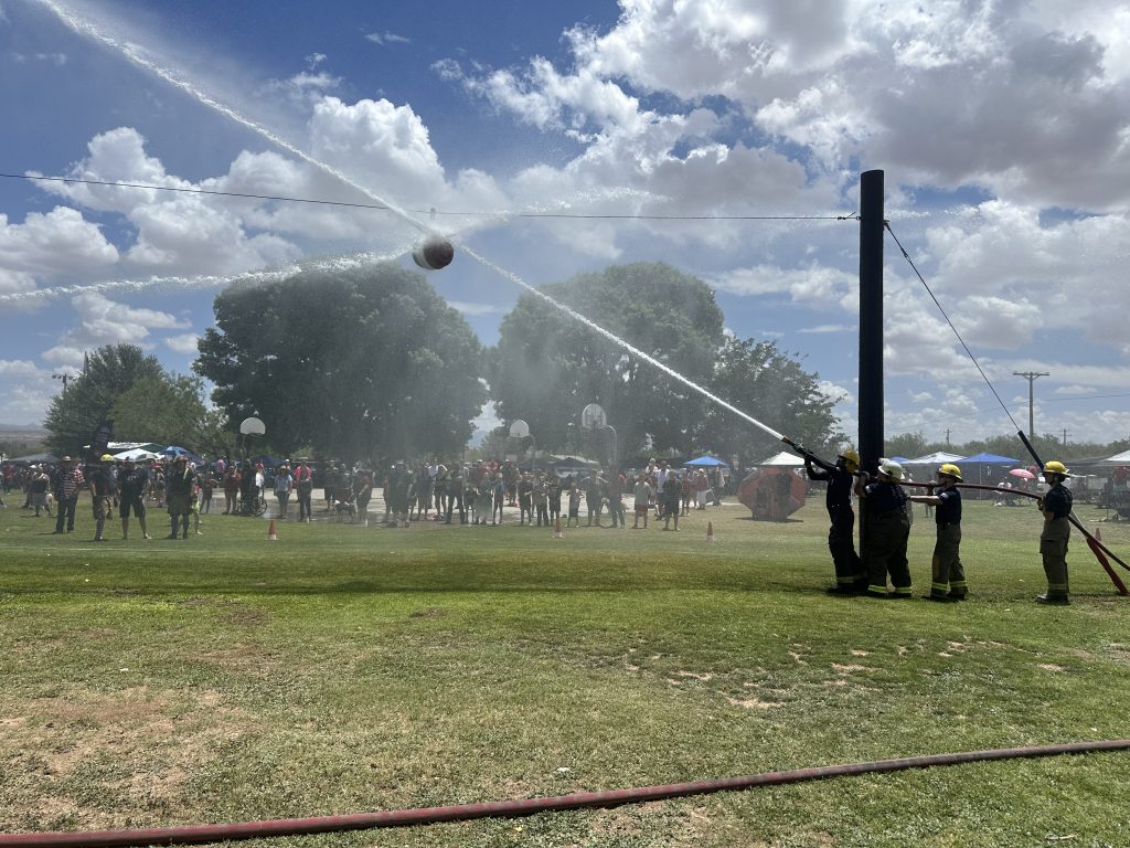 Water sprays across a grassy field during the annual Fourth of July water fight.